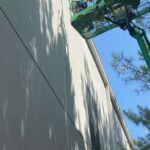 Picture of a person apply caulk on the exterior of a building