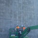 Image of two men on a cherry pick applying sealant to a new building