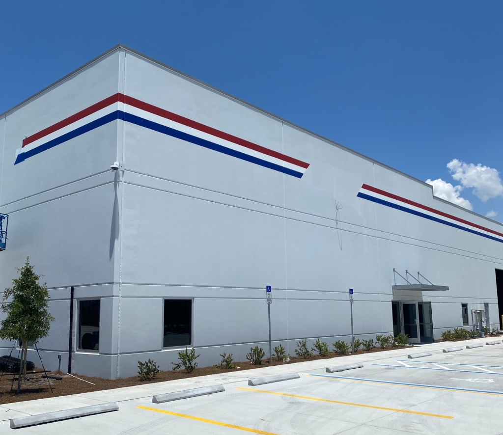 Modern white commercial building with red and blue accent stripe