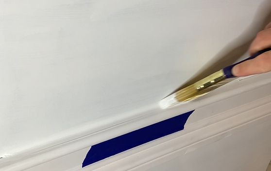 Tower AU-1 sealant being applied along blue painter's tape on a white wall